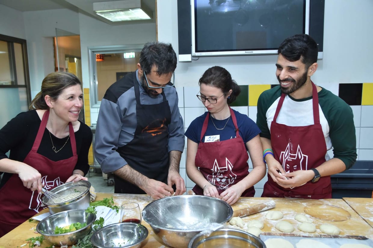 Team concentrates on making hummus and pita.